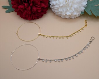 May include: Two nose rings with dangling chains of pearls. One ring is gold and the other is silver.