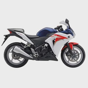 May include: A white, blue, and red sport motorcycle with the text "CBR" on the side. The motorcycle has a black seat and a silver exhaust pipe. The front fender is red.