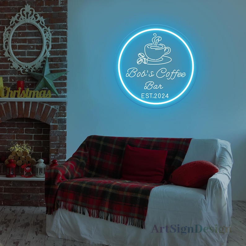 May include: A white neon sign with a blue glow, shaped like a circle, with a coffee cup and steam design. The text on the sign reads "Bob's Coffee Bar EST. 2024".