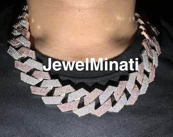May include: A large, silver and rose gold chain necklace with a Cuban link design. The chain is covered in small, clear and pink stones.