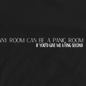 May include: Black t-shirt with white text that reads "Any room can be a panic room if you'd give me a fing second."