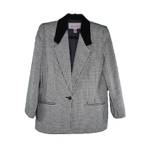 Può includere: Blazer a quadri bianco e nero con colletto in velluto nero. La giacca ha una chiusura con un solo bottone e due tasche anteriori.