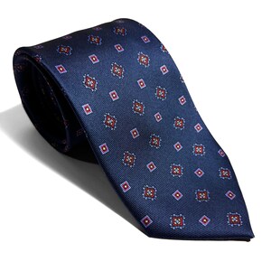 May include: A dark blue silk tie with a repeating pattern of small red, blue, and yellow squares.
