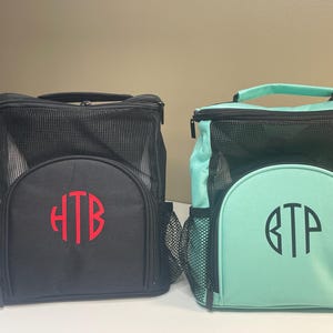 May include: Two square lunch bags with top handles and mesh upper sections. The black bag features a red monogram HTB, while the mint green bag features a black monogram BTP. Both bags have a front zippered compartment and side mesh pockets.