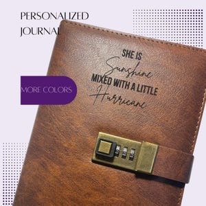 May include: A brown faux leather journal featuring a brass-colored combination lock on a strap. The cover is engraved with the text: SHE IS Sunshine MIXED WITH A LITTLE Hurricane. The journal includes a purple tab labeled MORE COLORS.