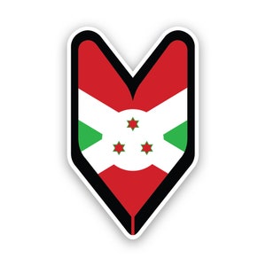 Può includere: Un adesivo rosso, bianco e verde con un contorno nero a forma di cuore. L'adesivo presenta la bandiera del Burundi, che include un cerchio bianco con tre stelle rosse a cinque punte.