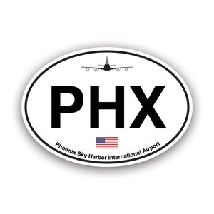 May include: Oval sticker with the letters PHX in bold black font. The sticker includes a silhouette of an airplane above the letters and the American flag below. The words "Phoenix Sky Harbor International Airport" are printed around the bottom edge.