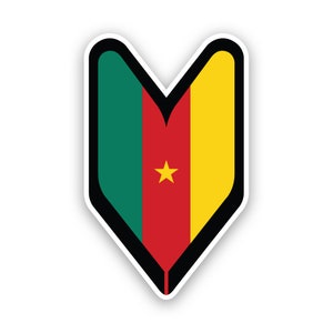 Può includere: Un adesivo raffigurante la bandiera del Camerun in una forma stilizzata a scudo. Il design della bandiera include strisce verticali verdi, rosse e gialle, con una stella gialla al centro. L'adesivo ha un bordo bianco e un contorno nero.