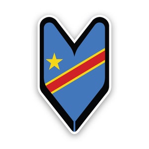 Può includere: Un adesivo a forma di cuore blu e rosso con una stella gialla e una striscia rossa diagonale. L'adesivo presenta la bandiera della Repubblica Democratica del Congo.