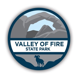 Könnte beinhalten: Ein blaues und graues kreisförmiges Emblem mit weißem Hintergrund. Das Emblem zeigt eine Silhouette eines natürlichen Felsbogens mit blauem Himmel dahinter. Der Text "VALLEY OF FIRE STATE PARK" ist in Schwarz unter dem Bogen gedruckt. Eine Silhouette eines Dickhornschafs ist in der unteren Mitte des Emblems gedruckt.