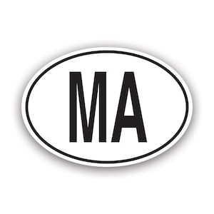 May include: An oval sticker in white, featuring the black letters "MA" within a black border. The design includes a subtle shadow, giving a raised appearance.
