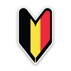 Può includere: Un adesivo a forma di cuore nero, giallo e rosso con un contorno bianco. L'adesivo presenta i colori della bandiera belga.