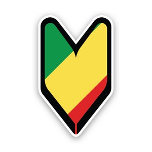 Può includere: Un adesivo a forma di V rivolta verso il basso, con un bordo nero. La V è riempita con i colori della bandiera della Repubblica del Congo: verde, giallo e rosso. L'adesivo ha un bordo bianco.