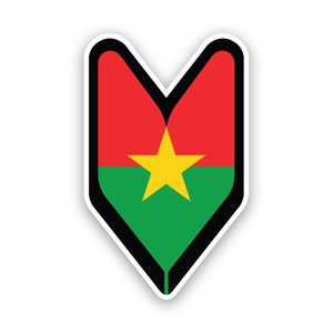 May include: A sticker depicting the flag of Burkina Faso. The design is a shield shape with a black border. The top section is red, the bottom is green, and a yellow star is in the centre.