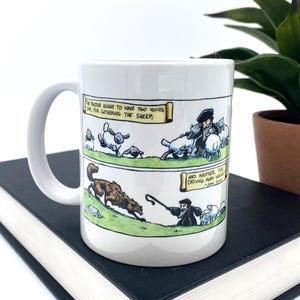 May include: White ceramic mug with a wraparound cartoon illustration. The illustration depicts a pastor with sheep and a wolf, with text that reads "The pastor ought to have two voices, one, for gathering the sheep, and another, for driving away wolves."