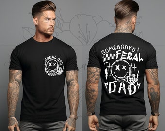 May include: Black t-shirt with a white graphic of a smiley face with crossed eyes and a hand giving the middle finger. The text "Feral Dad" is above the smiley face and the text "Somebody's Feral Dad" is below the smiley face.