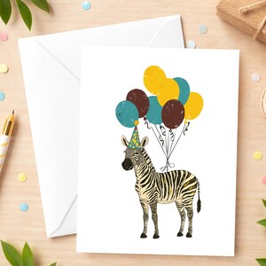 May include: A birthday greeting card featuring a zebra wearing a party hat and holding balloons. The balloons are in shades of teal, brown, and yellow. The zebra has black and white stripes. An envelope is visible in the background.