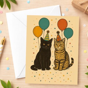 May include: A birthday greeting card featuring two cats with party hats and balloons. One cat is black, the other is tabby. The balloons are teal, orange, and red. The background is a light beige with star confetti.