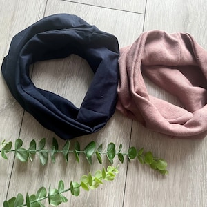 May include: Two fabric headbands, one black and one dusty rose. The dusty rose headband has a subtle textured pattern.