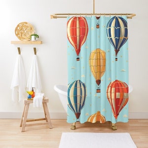 May include: A shower curtain with a blue background and a pattern of colorful hot air balloons. The balloons are red, yellow, and blue with white stripes. The balloons are flying in the sky with white clouds.