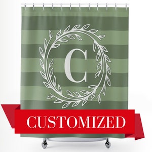 May include: A green and white striped shower curtain with a white wreath and the letter "C" in the center. The text "CUSTOMIZED" is printed on a red ribbon at the bottom of the curtain.