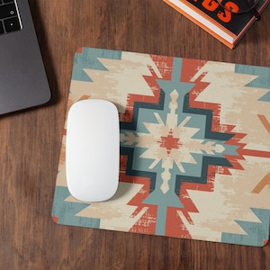 Puede incluir: Un ratón de ordenador blanco se encuentra sobre una alfombrilla de ratón con un patrón geométrico colorido. La alfombrilla de ratón tiene un esquema de color rojo, azul y beige con un aspecto desgastado y vintage.