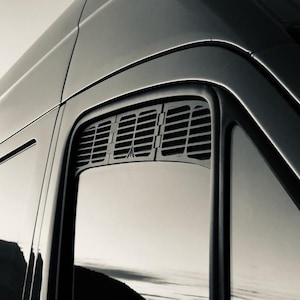 May include: A black van with a tinted window and a black vent above the window.