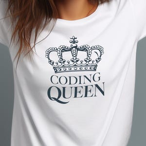 May include: White t-shirt featuring a navy blue crown design above the words "CODING QUEEN". The crown is detailed with intricate patterns. The shirt is made of a soft material and is suitable for casual wear.