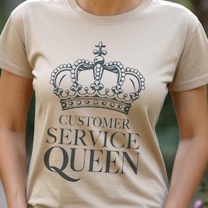Op de afbeelding: Een beige T-shirt met een zwarte kroon en de tekst "Customer Service Queen".