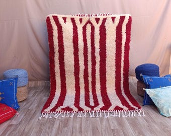 Könnte beinhalten: Ein rot-weiß gestreifter Teppich mit Fransenbordüre. Der Teppich ist aus Wolle und hat eine weiche, flauschige Textur.
