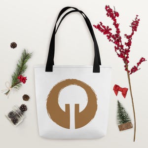 May include: A white tote bag with black handles and a brown circle design featuring a stylised tree. The design is reminiscent of a Japanese Zen garden.