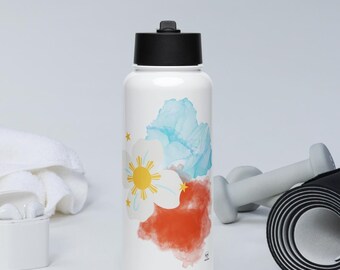 Puede incluir: Botella de agua aislada blanca con tapa negra, con un diseño floral en azul, rojo y blanco. El diseño incluye un sol amarillo y estrellas. La botella se muestra con accesorios de entrenamiento.