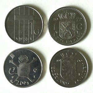 May include: Four silver Dutch coins, two with the year 1972 and the text "1 GULDEN NEDERLAND", and two with the year 2004 and a stylized image of a person.