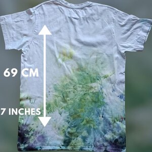 May include: White t-shirt with a tie-dye pattern in shades of green, blue, and purple. The shirt measures 27 inches in length.