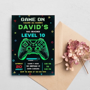 May include: A black and green video game party invitation with a neon green and blue video game controller graphic. The text reads "Game On Calling All Gamers! David's Has Reached Level 10". The invitation includes the date, time, and location of the party.