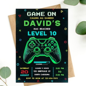 May include: A black and green birthday invitation with a neon green video game controller graphic. The text reads "Game On Calling All Gamers! David's Has Reached Level 10". The invitation includes details for the party, including the date, time, and location.