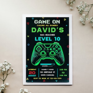 May include: A black and green video game party invitation with a neon green video game controller graphic. The invitation reads "Game On Calling All Gamers! David's Has Reached Level 10". The invitation also includes the date, time, and location of the party.