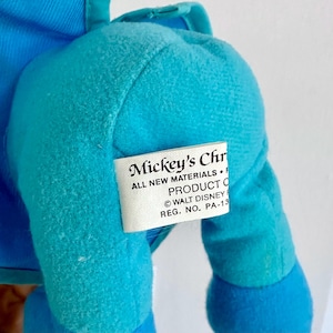 May include: A blue plush toy with a tag that reads "Mickey's Christmas. All new materials. Product of &copy; Walt Disney. Reg. No. PA-13."