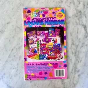 Puede incluir: Un paquete de espejo magn&eacute;tico Lisa Frank para taquillas. El paquete es rosa con salpicaduras de pintura coloridas y presenta im&aacute;genes de pegatinas, bol&iacute;grafos y otros &uacute;tiles escolares. El texto en el paquete dice "Cool School Gear".
