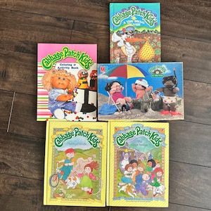 May include: A collection of five Cabbage Patch Kids items including a colouring and activity book, a puzzle box, and three storybooks titled A Very Special Delivery, Making Friends, and The Great Rescue, featuring colourful illustrations of dolls.