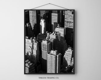 Könnte beinhalten: Schwarzweißes Luftbild einer Skyline mit hohen Gebäuden. Das Bild ist in einem schwarzen Rahmen mit dem Text "TIMELESS TRADING CO." unten gerahmt.