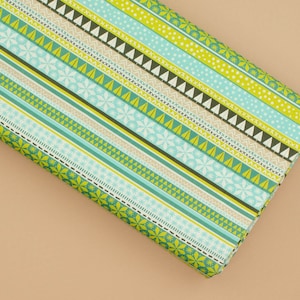 May include: Green and blue patterned wrapping paper with a repeating design of snowflakes, trees, and stripes.