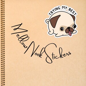 May include: A sticker featuring a cartoon pug with the text "TRYING MY BEST". The pug is light tan with a brown patch and tongue sticking out. The sticker is on a tan background with the words "Mellow Nook Stickers" in cursive.