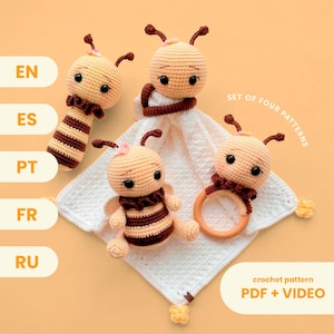 May include: A set of four handmade crochet bee-themed baby toys. The toys include a rattle, a security blanket with a bee head, a bee-shaped teether, and a bee with a striped body. The text on the image says "SET OF FOUR PATTERNS" and "crochet pattern PDF + VIDEO".