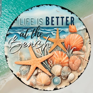 May include: A round, rustic-style sign with the text "Life is Better at the Beach" in white lettering. The background is a blue ocean scene with white waves and seashells. There are starfish and seashells in the foreground.