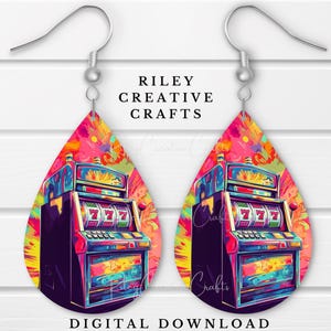 May include: A pair of teardrop-shaped earrings featuring a colorful slot machine design. The earrings have a vibrant, tie-dye style background with the text "Riley Creative Crafts" and "Digital Download". The slot machine displays three sevens.