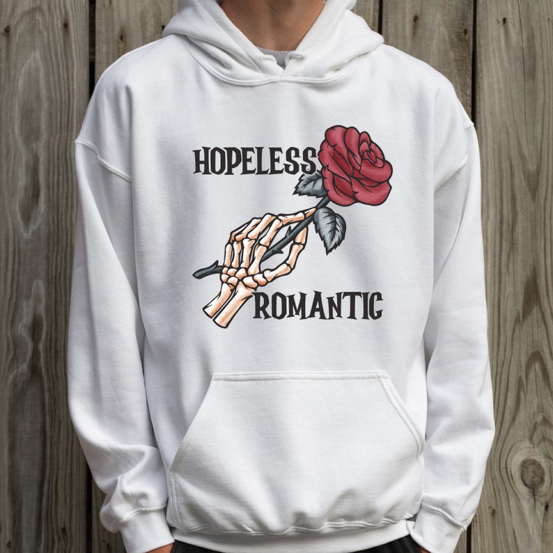 May include: White hoodie with a skeleton hand holding a red rose and the text "HOPELESS ROMANTIC".