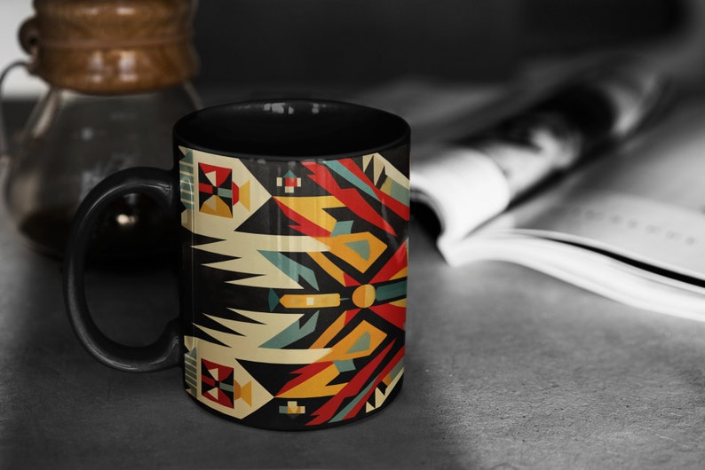 May include: Black coffee mug with a geometric pattern in shades of red, yellow, blue, and white. The pattern is reminiscent of Native American art.