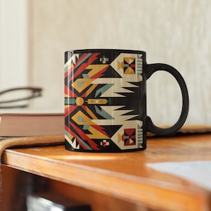 May include: Black ceramic mug with a geometric pattern in red, yellow, blue, and white. The pattern is reminiscent of Native American art.