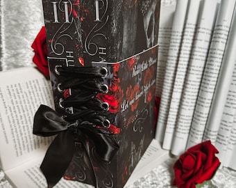 May include: Two black hardcover books with red and black floral designs. The books are bound together with a black ribbon and have the text "Run Like Hell" and "Let me love you like a storm" on the cover.